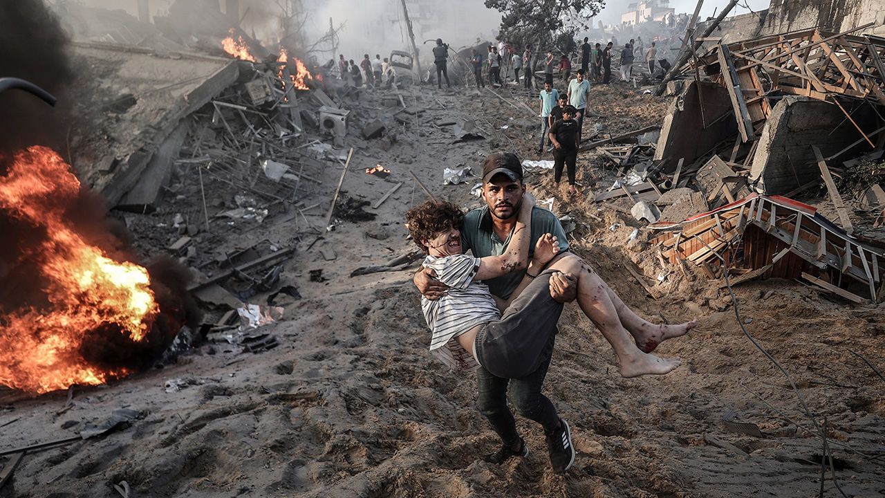 Injured Palestinians flee an area, hit by Israeli airstrikes, in Gaza.