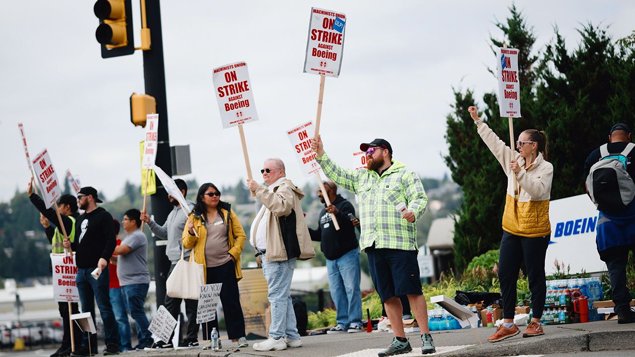 Striking workers picket outside of a Boeing production facility 